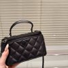 Chanel Classic Lambskin Vanity Bag with Top Handle in black leather, featuring black hardware and iconic Chanel CC logo.