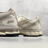 Close-up of the ASICS GEL-Kayano 12.1 heel detail featuring embroidered logo, FluidRide midsole foam, and beige synthetic overlay