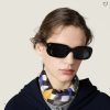 Model wearing Miu Miu black rectangle sunglasses with checkered scarf